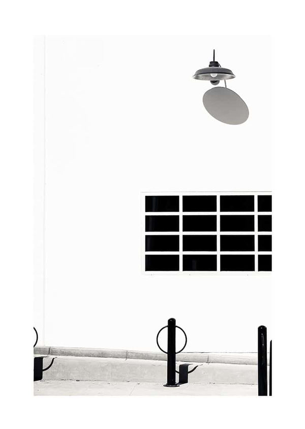 Black lamp on a white wall with grid window and minimal street elements, featured on a poster.