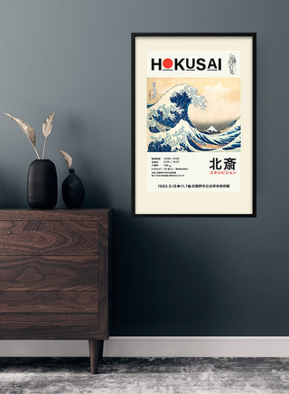 Framed Hokusai art poster of "The Great Wave" displayed above a wooden dresser in a modern room.