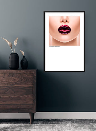 Minimalist poster featuring glossy red lips, displayed above a wooden dresser in a modern room.