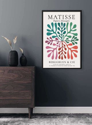 Framed Matisse Inspired Colored Coral Plakat on a dark wall above a wooden dresser with vases.