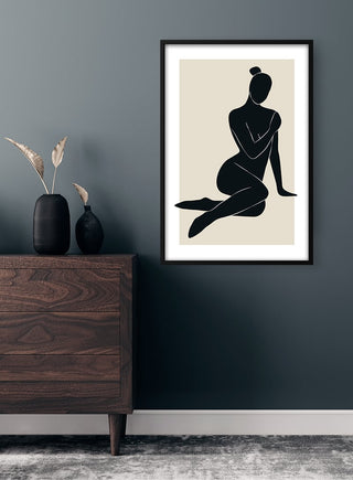Framed Abstractions Plakat featuring a minimalist silhouette of a seated woman, displayed above a modern dresser.
