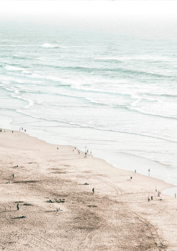 A serene beach scene with gentle waves and people walking along the sandy shore, perfect for coastal decor.