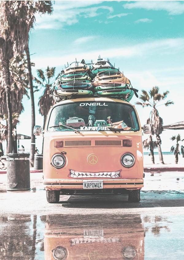 Orange van loaded with surfboards parked on a sunny beach, palm trees in the background.