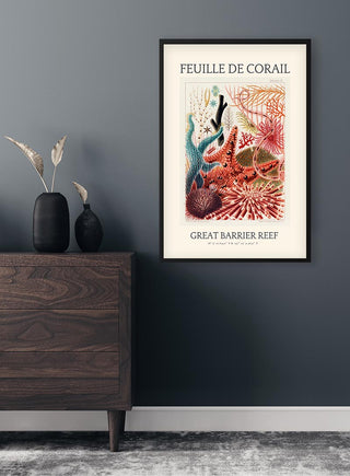 Framed vintage coral illustration with "Great Barrier Reef" text, displayed on a dark wall above a wooden dresser.