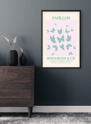 Framed Inspired Papillon No. 03 Plakat on a dark wall, featuring blue butterflies and vintage typography.