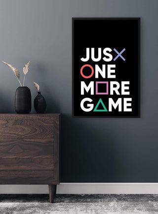 Framed "Just One More Game" poster with gaming symbols, displayed above a dresser in a modern room.