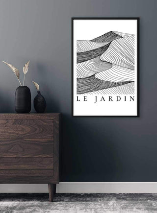 Le Jardin Black Plakat abstract line art in black frame, displayed on a dark wall above a wooden dresser.