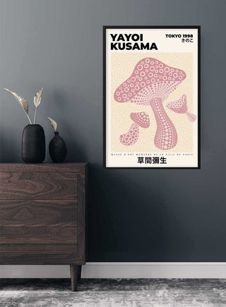 Poster of Yayoi Kusama's Pink Mushroom artwork hanging on a dark wall above a wooden cabinet.