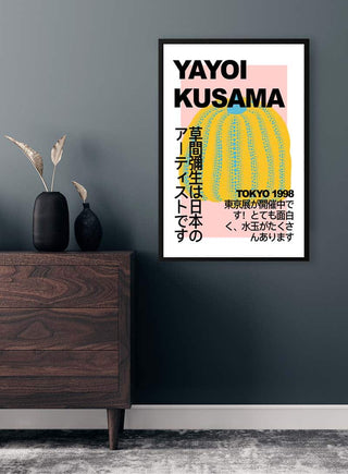 Framed Yayoi Kusama Pumpkin Plakat with Japanese text hangs above a dark wood dresser in a modern room.