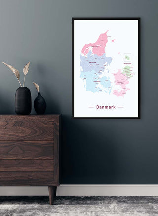 Framed Danmarkskort No 01 Plakat map on a wall above a dark wooden dresser with vases.