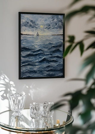 Ocean for my sister by Maya in a black frame above a glass table with crystal glassware