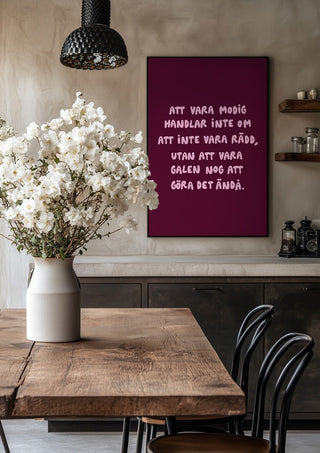 Modig by Grafik bageri in a black frame above a rustic table with white flowers