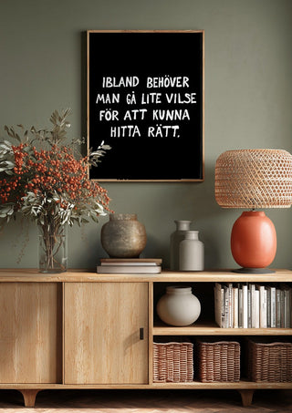 Gå vilse by Grafik bageri above a wooden sideboard on a sage green wall