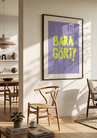 Bara gört! by Grafik bageri in a black frame in a bright dining room with wooden chairs