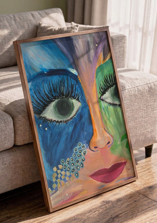 Blue and Green Face by Camilla Sabrina in a walnut frame leaning against a grey sofa
