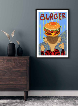 Framed På Hovedet Burger art by Nina Broen, featuring a person with a burger on their head, hanging on a wall.