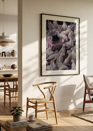 One with Nature by Daukantė in a black frame in a bright dining room with wooden chairs