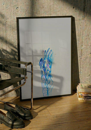 Blue ChrysAlice by Alice Ruja in a black frame leaning against a concrete wall by a steel chair