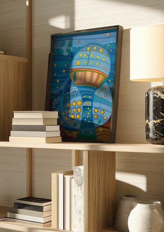 Once upon a blue moon by Gerard Ceulemans in a dark frame on a wooden shelf beside books and a lamp