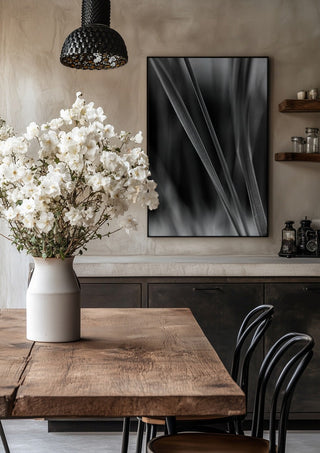 Diagonale Halme by Guido Lucker in a black frame above a rustic table with white flowers