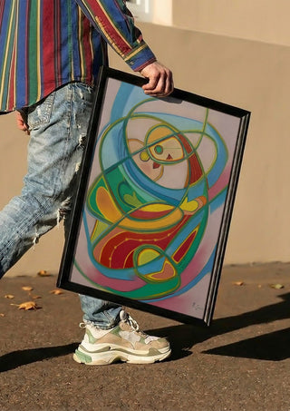 Embrace by Gerard Ceulemans carried in a black frame along a sunny street