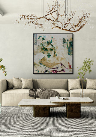 Norma by Mushk in a black frame above a beige sofa under a branch chandelier
