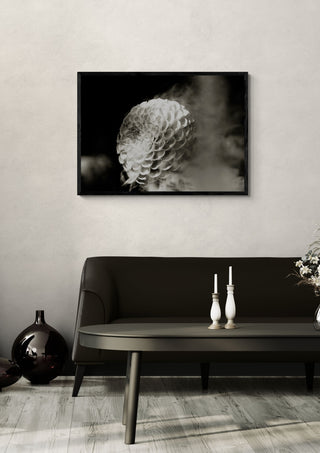 Lunar Bloom III by Guido Lucker in a black frame above a dark sofa with candlesticks and a vase