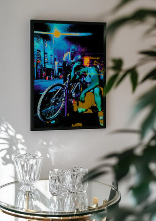 Bike Boys by Pelecan Schneider in a black frame above a glass table with crystal glassware
