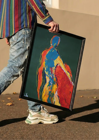 Figure in Green by René J carried in a black frame along a sunny street