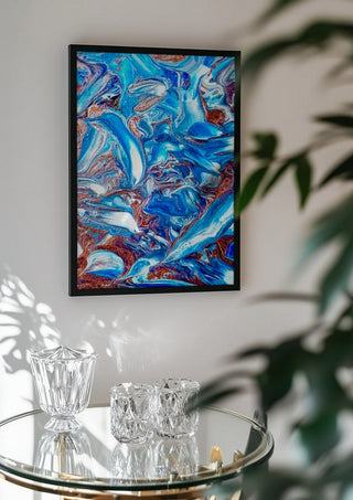 Blue Waves by Da Winters in a black frame above a glass table with crystal glassware