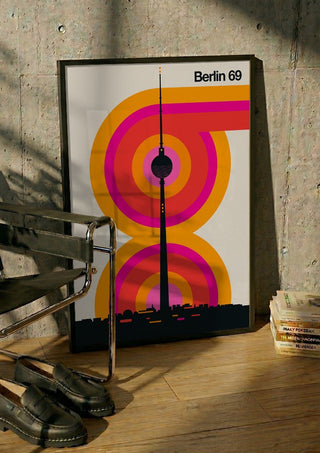 Berlin 69 by Bo Lundberg in a black frame leaning against a concrete wall by a steel chair