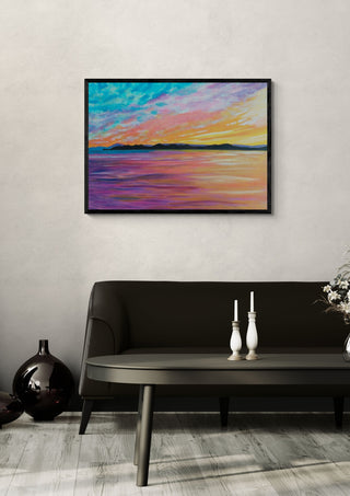 Colours of the Sky by Finbar Stevens in a black frame above a dark sofa with candlesticks and a vase