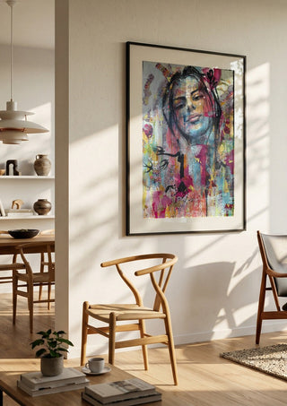 Sehnsucht by Anke Fillies in a black frame in a bright dining room with wooden chairs