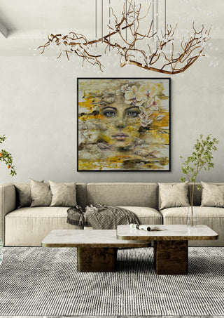 Symbiose by Anke Fillies in a black frame above a beige sofa under a branch chandelier