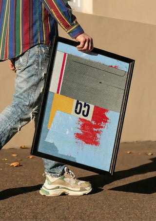 No.65 by Kareem Rizk carried in a black frame along a sunny street