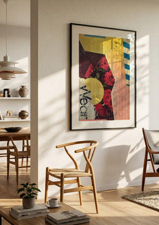 Roses by Kareem Rizk in a black frame in a bright dining room with wooden chairs