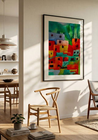 Houses of Favela by Nittaart in a black frame in a bright dining room with wooden chairs