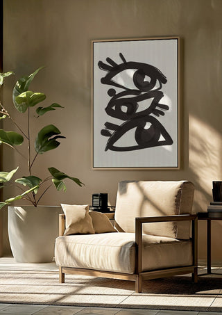 Abstract line art eyes 3 by ThingDesign framed above a beige armchair beside a potted plant