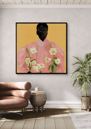 Girl Holding Flowers 2 by ThingDesign in a black frame above a leather armchair beside a palm