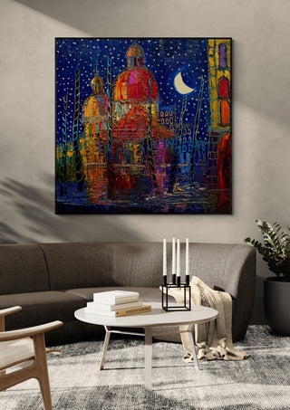 Domes under the Moon by Justyna Kopania in a black frame above a dark sofa with candlesticks on a round table