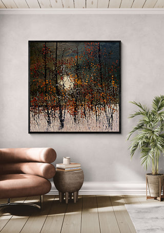 Autumn Trees in the Sun by Justyna Kopania in a black frame above a leather armchair beside a palm