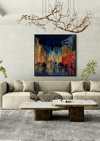 Night Street with Red Umbrellas by Justyna Kopania in a black frame above a cream sofa under a branch chandelier