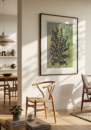 Glyphs on Green by John Larkin in a black frame in a bright dining room with wooden chairs