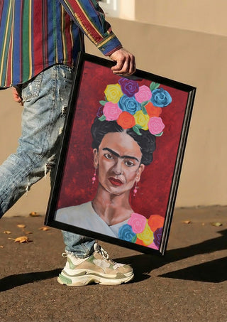 Frida Kahlo by creatievananne carried in a black frame along a sunny street