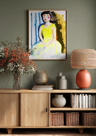 Yellow Dress by DNF above a wooden sideboard on a sage green wall