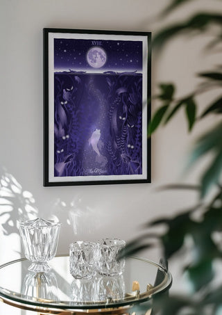 The Moon by Sciurus tarotus in a black frame above a glass table with crystal glassware