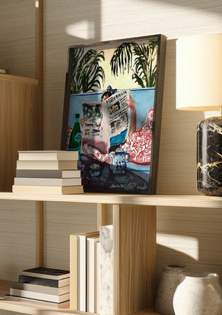 Sunday read at The Phoenicia, Malta by Mariam De Giorgio in a dark frame on a wooden shelf beside books and a lamp