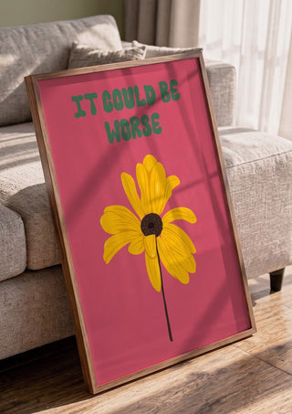 It Could Be Worse by Jakob Falkenberg in a walnut frame leaning against a grey sofa