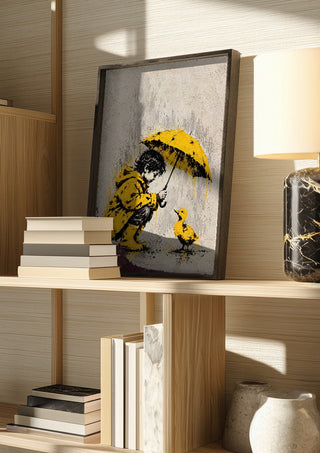 A Little Shelter by Matthews Gallerie in a dark frame on a wooden shelf beside books and a lamp