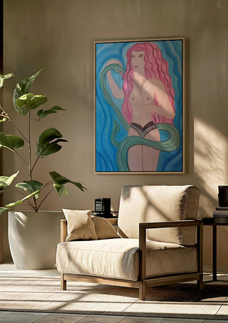 Eva in Paradise by Carmen Coduri framed above a beige armchair beside a potted plant
